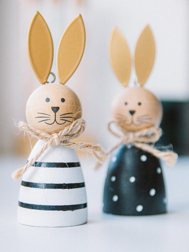 Cute wooden Easter bunny figurines with colorful outfits and playful designs.