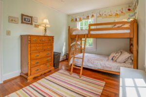 Warm and inviting children's bedroom featuring a classic wooden bunk bed and colorful decor.